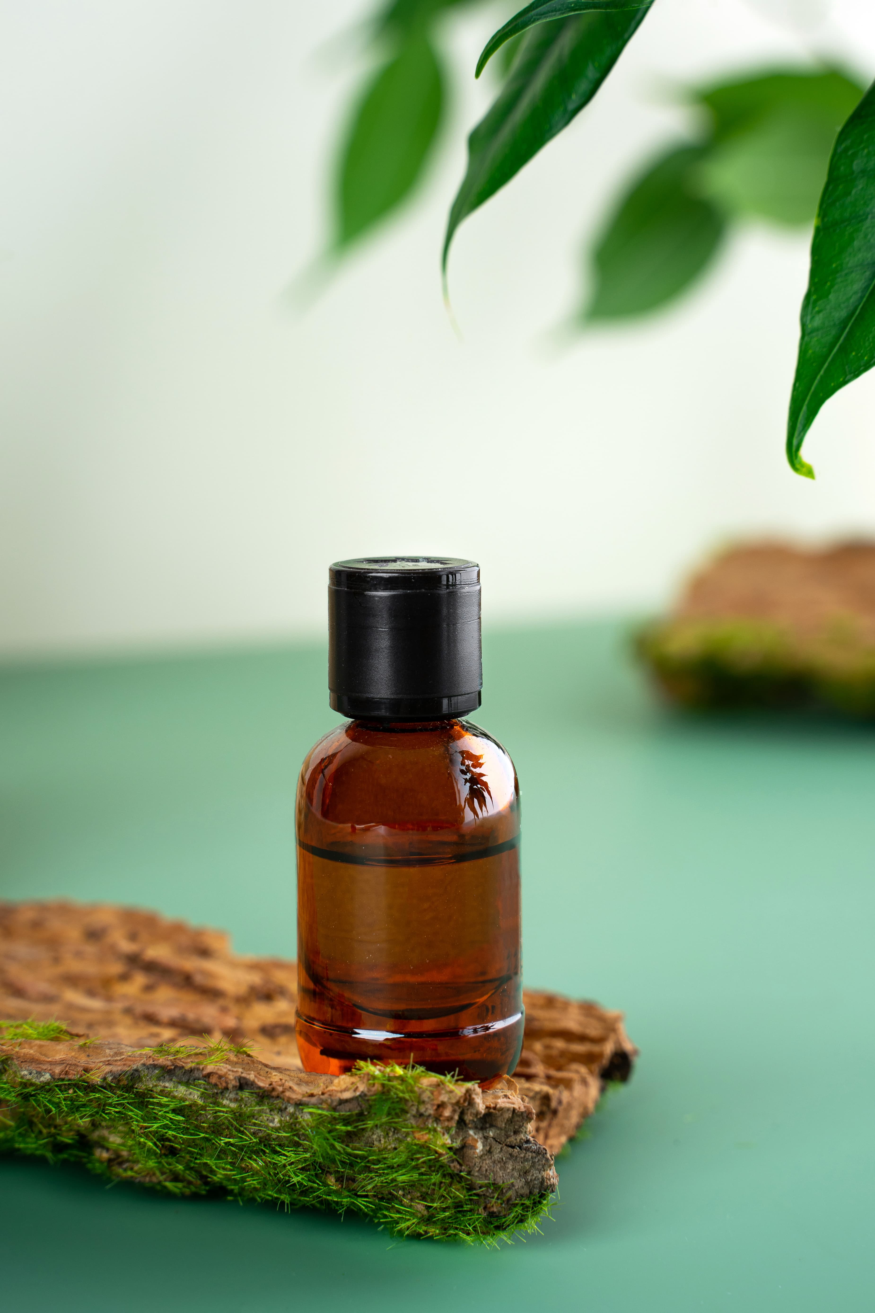 Sandalwood Essential Oil bottle on green surface